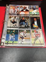 binder page showing nine Topps multi-sport cards in sleeves