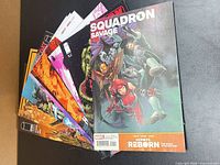 Stack of comics showing Squadron Savage on top with others partially visible