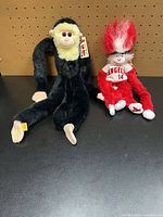 Both plush toys side by side on black surface