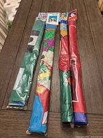 Four sealed rolled nylon flags side by side in plastic sleeves