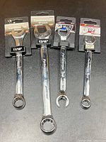 Front view of four packaged Performance Tool combination wrenches