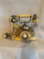Front view showing handset on cradle, rotary dial, cord