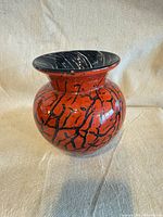 Front view of red and black crackle glass vase
