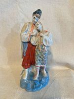 Front view of porcelain couple figurine on blue base
