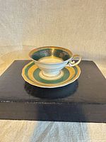 Teacup on saucer, front view showing color and gilt