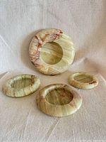 Four green onyx ashtrays displayed top view