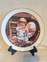 Front view of full plate on stand showing complete design and gold rim