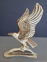 Front view of carved antler eagle figurine showing feather detail and signature area