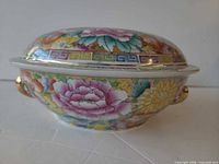Side view of covered tureen showing floral pattern, gold handles