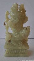 Front view of celadon soapstone koi fish carving, showing color, form and plinth