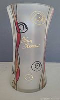 Full view of frosted glass vase front showing abstract design and signature
