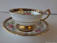 Paragon floral teacup on saucer showing cobalt blue and gold border