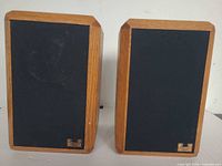 Front view of both speakers with grilles and logo badges