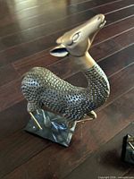 Single gazelle figure showing texture, brass head and legs, mounted on base