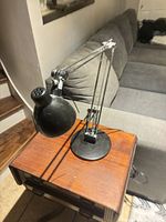 Front view showing black shade, silver arms, round black base