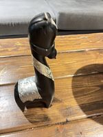 Front/side view of wooden figurine displaying overall shape and silver neck band