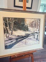 Full view of framed winter birch landscape painting on easel
