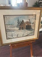 Full view of framed painting on easel