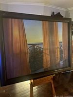 Full view of framed painting on easel