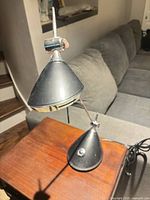 Front view of black and chrome adjustable desk lamp on side table