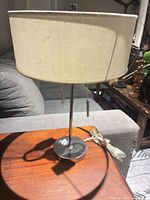 Front view of chrome table lamp showing shade, stem, base, pull chains and cord
