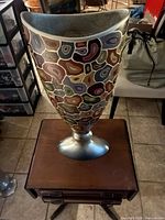 Full view of multicolor abstract resin vase on silver-tone base