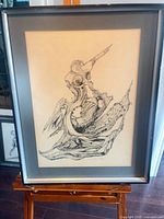 Full view of framed drawing on easel
