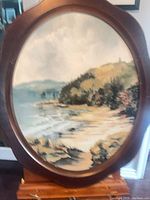 Front view of framed oval seascape painting