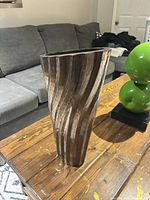 Front angled view showing wavy ribbed brown bronze exterior