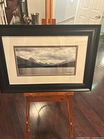 Framed photographic print on easel showing full artwork, frame, mat and image