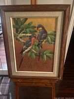 Full view of framed parrot painting on easel