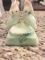 front view showing two stone cockatoos and dish