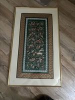 Full view of framed silk tapestry showing mats and gold frame
