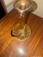 Full view of amber glass bud vase with spiral handle