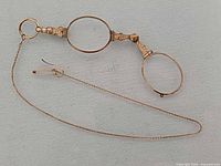 Full view of lorgnette extended with chain and clasp visible