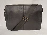 Front view of Boconi leather messenger bag showing flap and strap