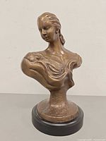 Front view of bronze-tone mother and child bust on black base