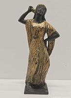 Front view of ceramic figure showing gold gown and pose