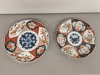 Both Imari plates side by side showing full designs and size comparison