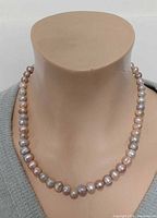 Necklace displayed on bust, full front view showing mixed pastel pearls