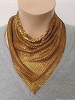 Necklace displayed on mannequin, front view showing gold mesh drape