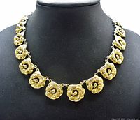 Full view of gilt sterling floral necklace displayed on bust