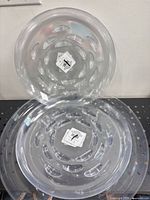 Two stacked clear plastic saucers showing size and transparency