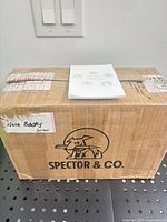 Sealed Spector & Co. box with note pad on lid