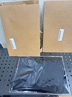 Two sealed cardboard sleeves and one visible stack of foil sheets inside plastic