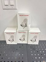 Four boxed bracket chargers stacked on perforated shelf