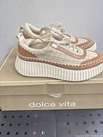 Side view of both sneakers atop original box