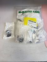 Bag labeled McMaster-Carr containing multiple sealed brackets
