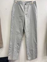 Full view of light grey dress pants hanging