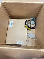 Overall view of box with flat cardboard, headbands and small bags
